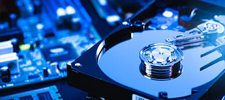 A hard disk with a see-through case on top of a computer board